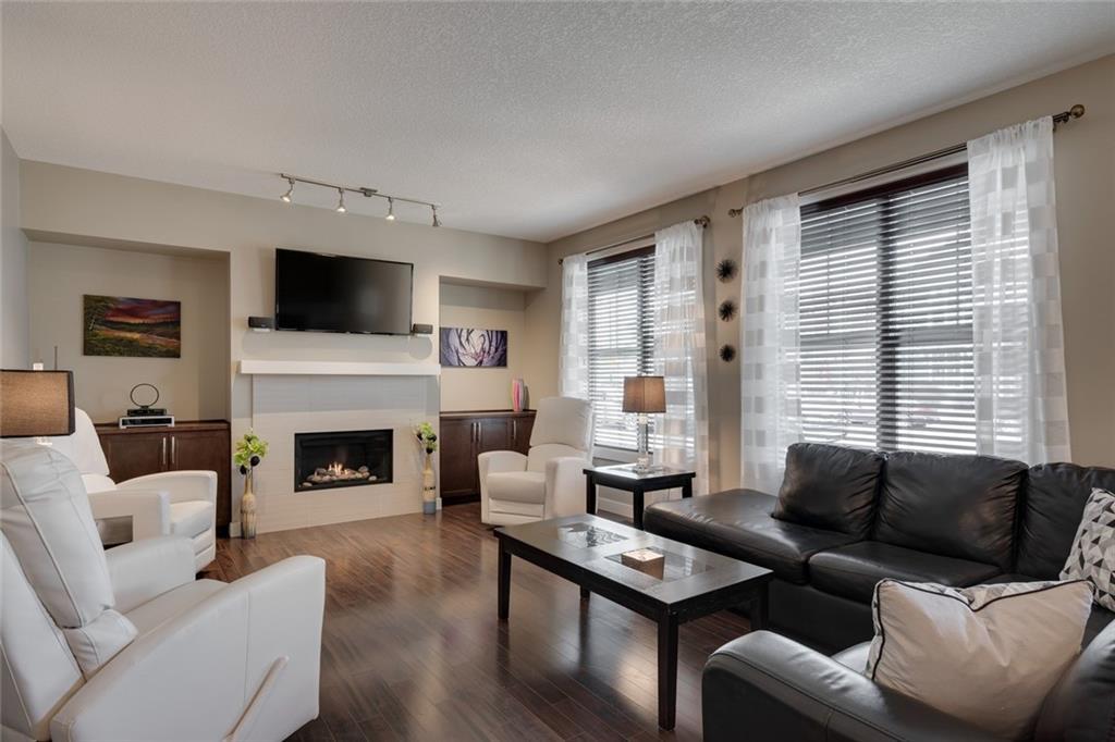 Bright open living room with built-in fireplace and oversized windows.