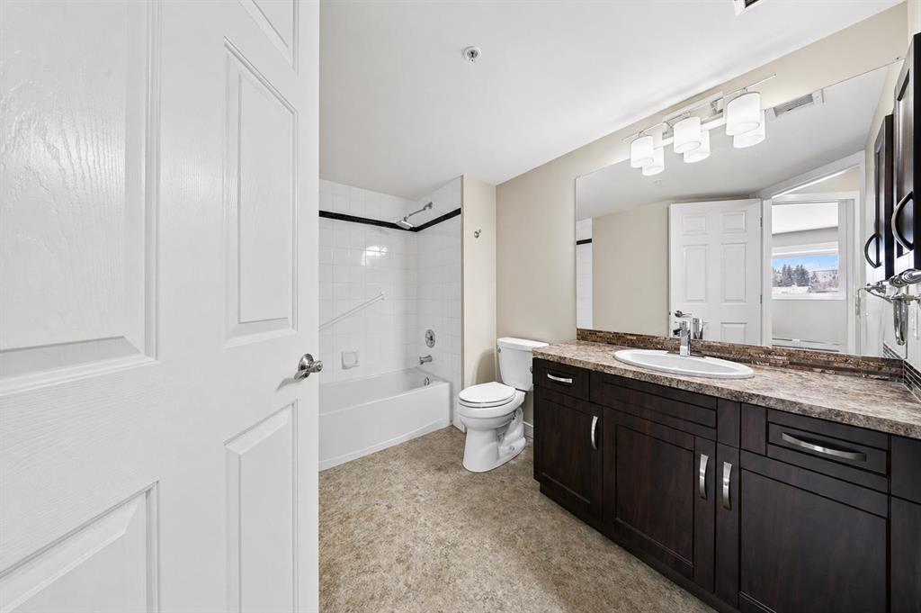 Full bathroom with tub, vanity, and large mirror