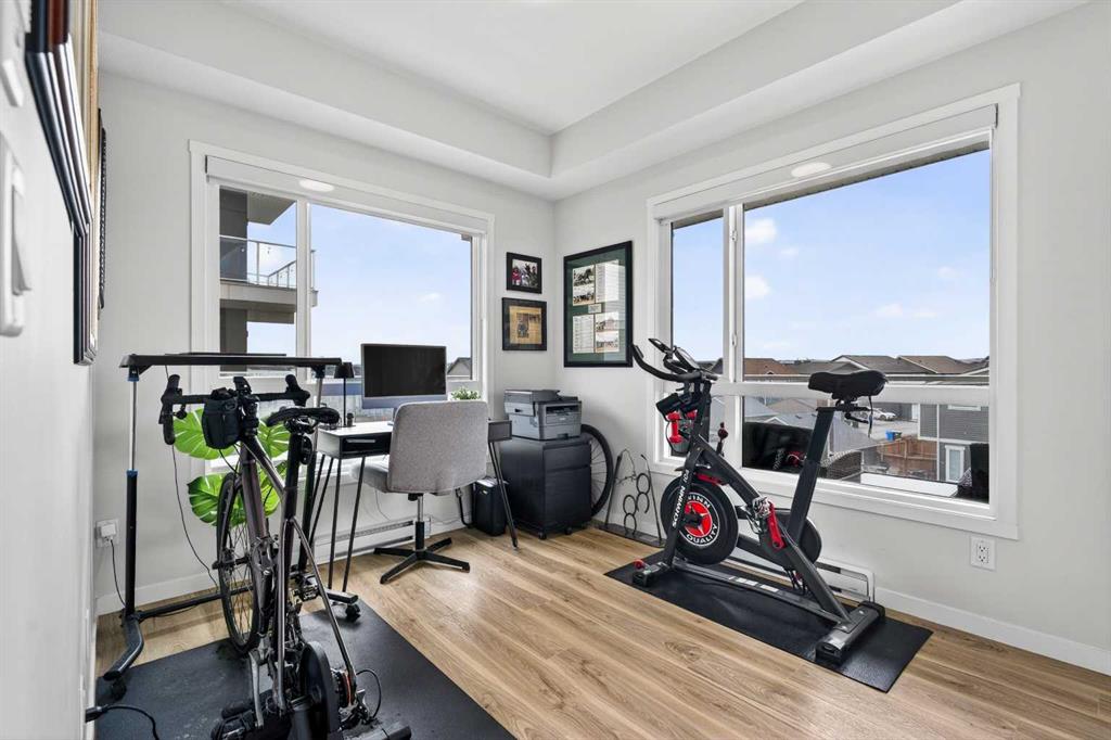 Second bedroom set up as a home gym and office with corner windows