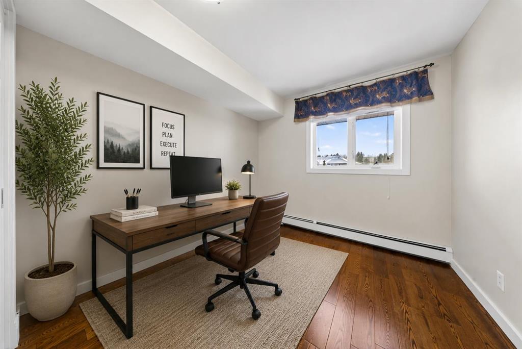 Second bedroom set up as a home office with desk and natural light